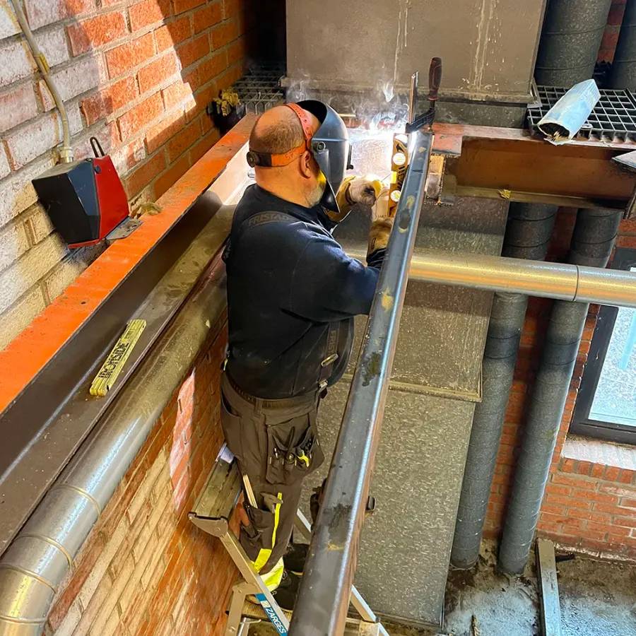 Man som svetsar i byggkläder på en byggarbetsplats