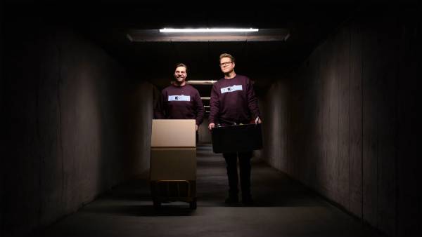 Två stycken skyddsrumstekniker från Bergsäkra AB som går i en korridor på väg till ett skyddsrum för att utföra en besiktning.